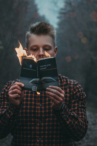 Homem lê livro em chamas