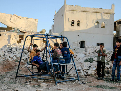 Poor children wander and play through the ruins of a devastated city, where destruction and loss surround them