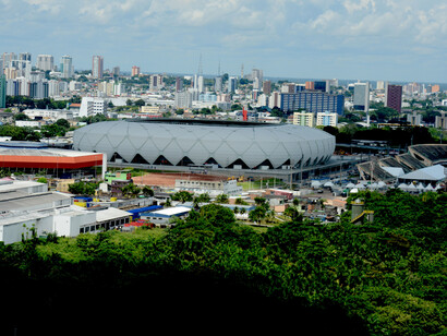 Arena Amazônia em meio à malha urbana, onde se vê o desenho de sua estrutura em aço. Fotografia Chico Batata
