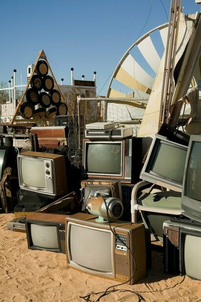 Stacks of ageing televisions and broken electronic equipment, symbolising the environmental burden created by discarded technology