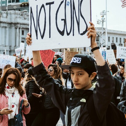 A crowd of demonstrators holds up handmade signs demanding gun reform, a visual cry for action against the ongoing crisis of gun violence in America