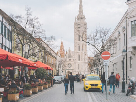 People walking on sidewalk near building during daytime, beautiful street close to Saint Matias Church, Budapest, Hungary