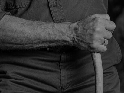 Using a cane because assistance is needed while walking due to Parkinson's disease