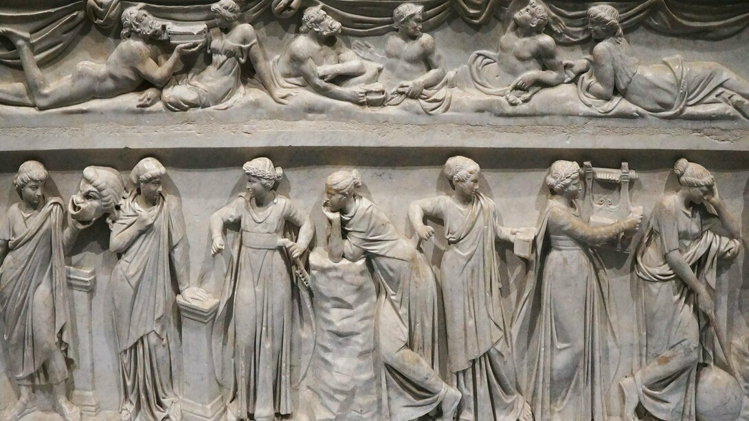"Sarcófago das Musas", representando as nove Musas da mitologia grega, divindades associadas às artes e ciências. Elas eram filhas de Zeus e Mnemosine e cada uma delas era responsável por uma área específica do conhecimento humano e seus atributos. Escultura em mármore, da primeira metade do século II d.C., encontrado na Via Ostiense. Na Grécia Antiga, o termo “mouseion” (de onde deriva a palavra “museu”) era utilizado para designar um lugar dedicado às musas — divindades inspiradoras das artes e das ciências