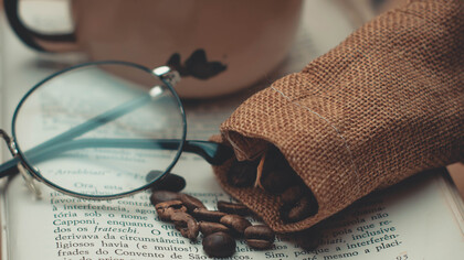 Xícara de café sob a mesa para acompanhar a leitura de um livro