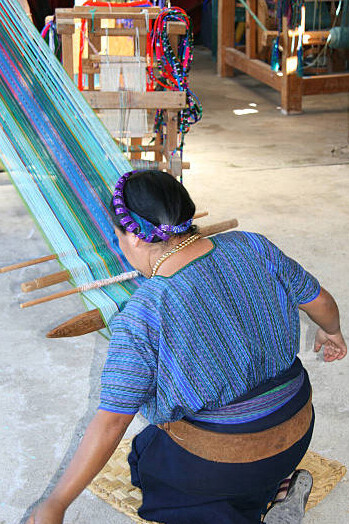A Mayan artisan weaving intricate patterns by the serene shores of Lake Atitlán, Guatemala, preserving ancient weaving techniques