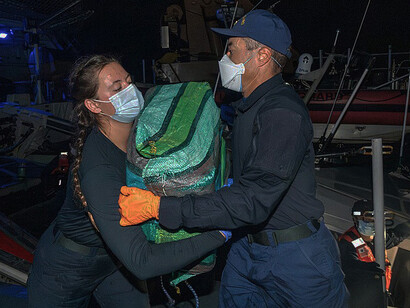 A U.S. Coast Guard crewmember carries a bale of cocaine seized by the crew of the Coast Guard Cutter Kimball (WMSL 756) during a patrol in the Eastern Pacific Ocean on March 28, 2025