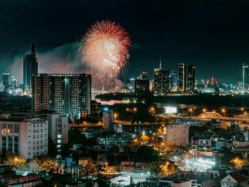 The illuminated skyline of Ho Chi Minh City provides a stunning backdrop for a spectacular fireworks show, highlighting the city's dynamic blend of urban development and cultural celebrations