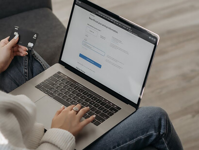 In a display of careful precision, a woman inputs her card information into her laptop