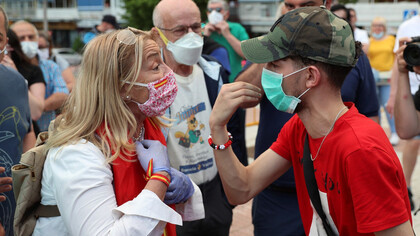 Un par de manifestantes con posiciones contrarias discuten la gestión del gobierno español