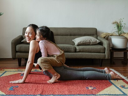 A happy mother and child practising yoga together, positive attitude