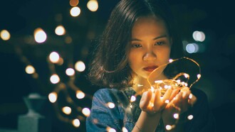 Donna con sguardo triste con luci di Natale. Il Natale e la solitudine: ricordi di festività passate e desiderio di appartenenza