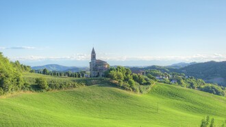 Verdi colline di Montesegale (PV) con la chiesa dei Santi Cosma e Damiano, Italia