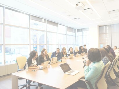 A long table conference meeting with a diverse group of employees, absence of discrimination at work