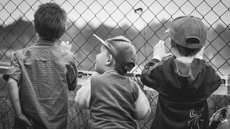 Meninos vigiam juntos o terreno em que brincam