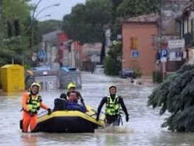 Delle persone usano un gommone per attraversare le strade inondate, Emilia Romagna, Italia