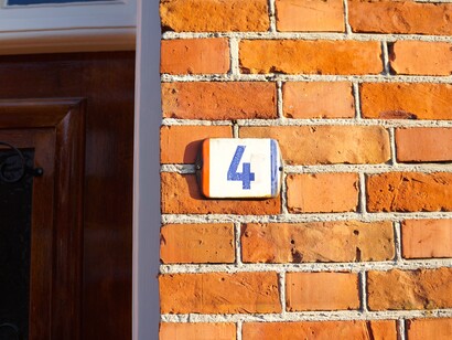 I differenti colori nazionali nelle targhe indicanti il numero civico stabiliscono la nazionalità dell’edificio, Baerle-Nassau, Paesi Bassi