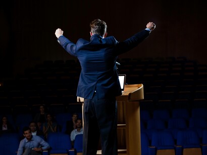 Un politico sul palco, arringa il pubblico in un auditorium