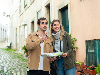 Tourists walking through the street while checking a map, Lisbon, Portugal