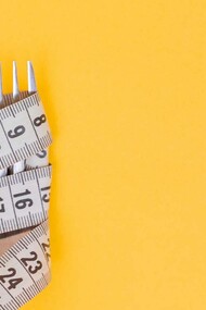 Measuring tape wrapped around a fork, showing the importance of addressing the causes of obesity