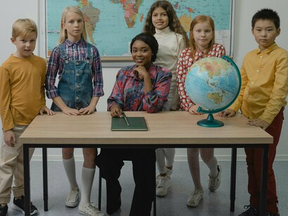 Turma de escola com professora. Estudos apontam que sistemas com forte ênfase em accountability tendem a apresentar melhores resultados educacionais. Por exemplo, (Hanushek & Raymond, 2005) demonstraram que estados norte-americanos que adotaram políticas de responsabilização tiveram crescimento significativo nas médias de desempenho dos alunos em testes padronizados