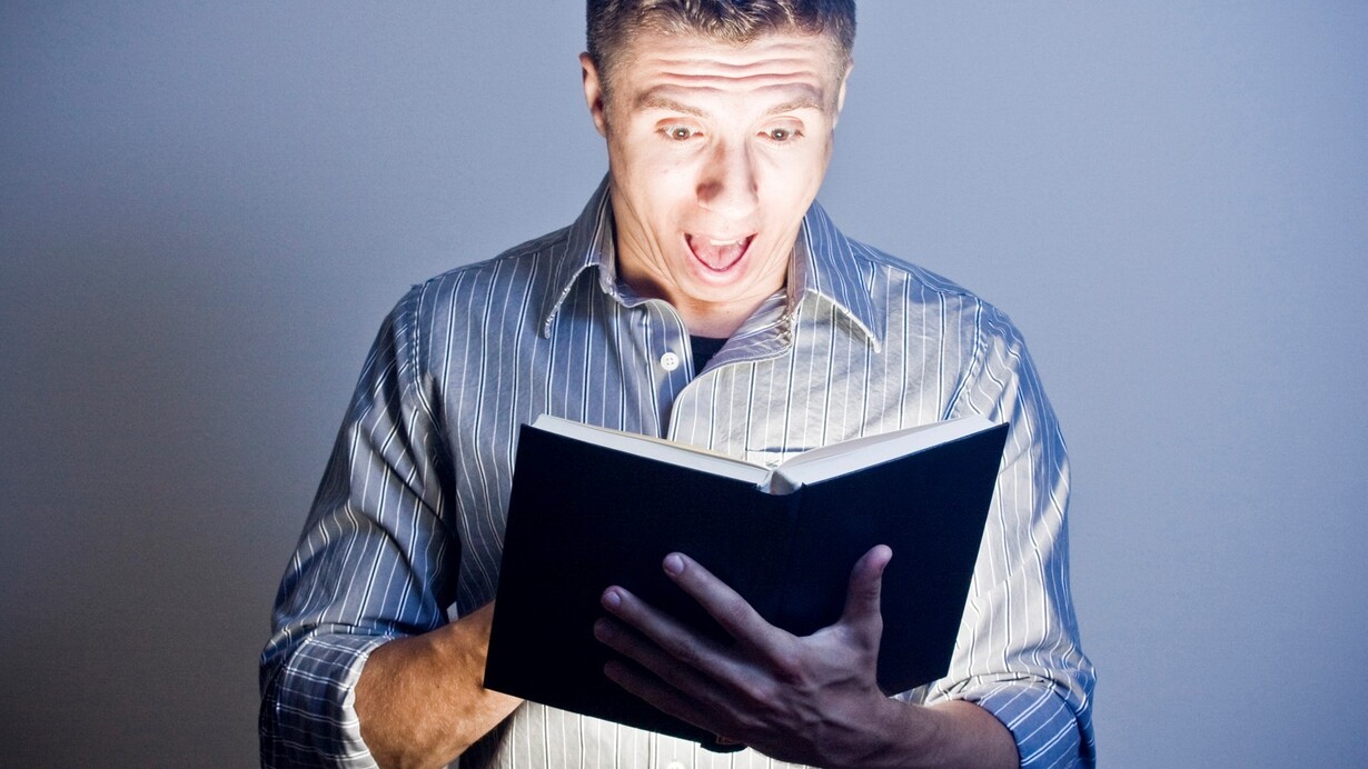 Joven deslumbrado por el libro que está leyendo