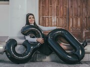 A woman sitting on the floor with balloons, celebrating her 30th birthday