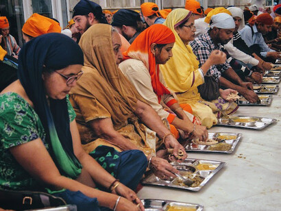 People sitting together to enjoy the Langar