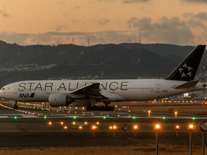 Aereo su una pista di atterraggio con un tramonto chiaro sullo sfondo
