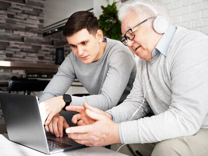 An elderly man engaging with digital technology designed to aid dementia management using AI