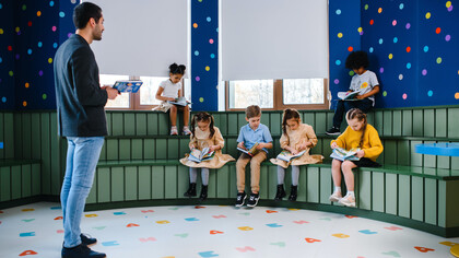 Professor com alunos em sala de aula para hora da leitura