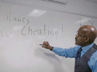 Le professeur explique les règles en les notant au tableau