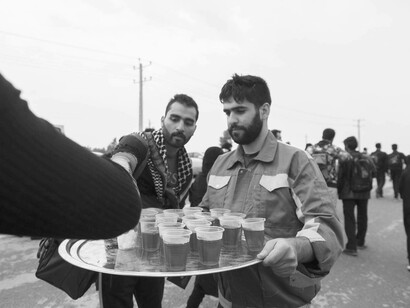 A Muslim man is playing his part and helping his fellow jihadist brothers by serving them drinks