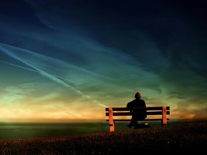 Un hombre contempla el cielo desde un banco