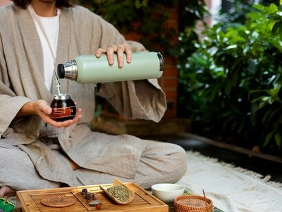A man holding a cup in nature, embodying the connection between Ayurveda, genomics, personalized medicine, and Ayurvedic herbs