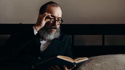 Homem judeu lê atentamente um livro 