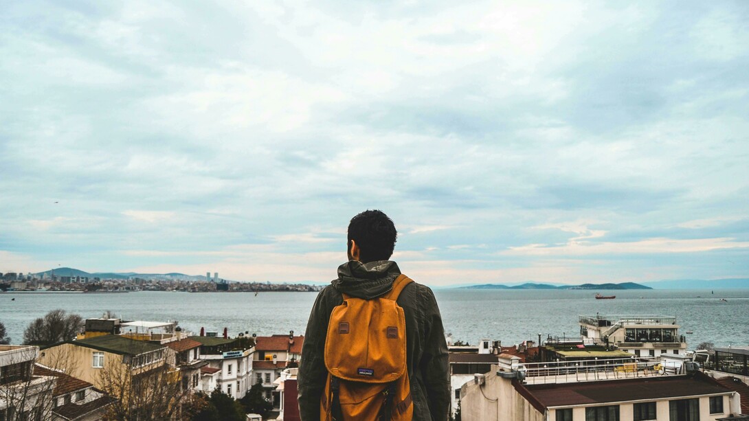 Homem contempla paisagem. Viver em um novo país é uma experiência que envolve muito mais do que aprender a viver em um novo lugar, na verdade, trata-se de descobrir uma nova versão de si mesmo e nem sempre as pessoas estão preparadas para isso