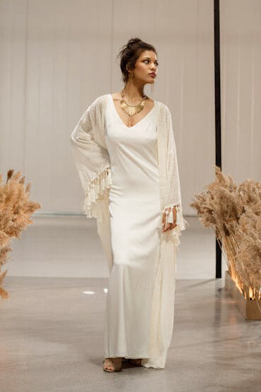 Amidst economic complexities, a model stuns in a luxurious white gown, reflecting industry strategies for future growth