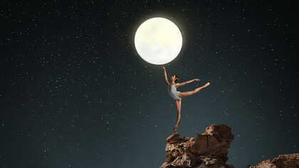 A ballerina gracefully holding the moon aloft