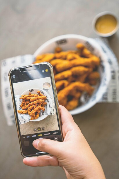 Una persona che fa una foto a del cibo fritto