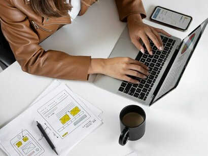 Top-down shot of a reporter working on her laptop, immersed in writing a story