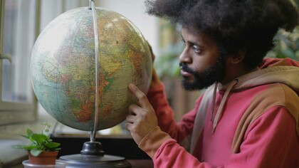 A young Kenyan showcasing countries where English has spread across the globe 