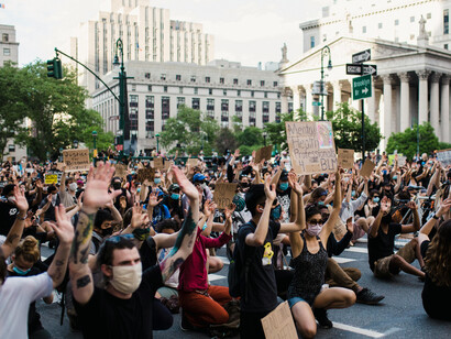 New York, United States. A crowd of protesters kneels while holding signs