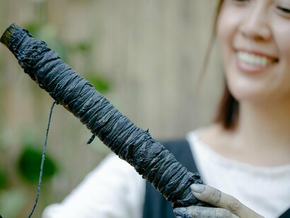 Tingimento artesanal de tecido. Optar por produção nacional ou de proximidade reduz não só as emissões de transporte, como também apoia as comunidades locais. Esta lógica é visível em marcas portuguesas que apostam na transparência, na produção ética e em edições limitadas