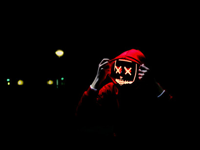 Personne masquée avec un sweat-shirt rouge. 