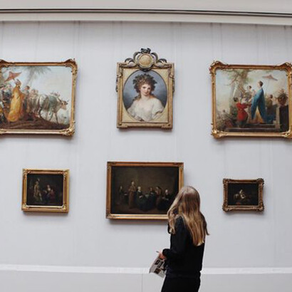 A young woman looking at a painting in a gallery