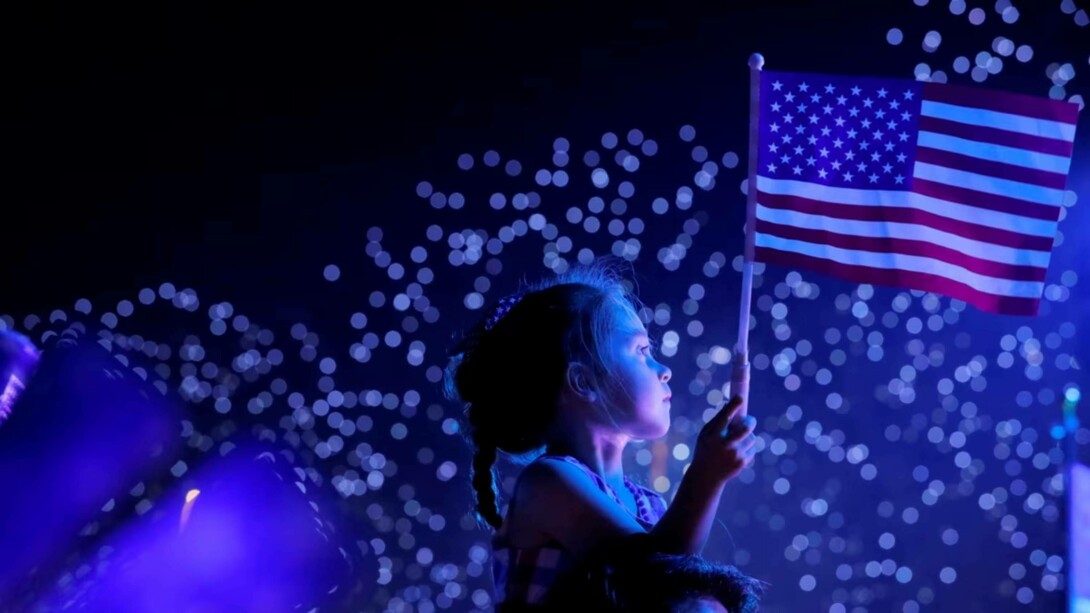 A little girl holding the American flag, celebrating Independence Day on July 4th