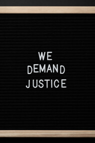 Frase de protesto em um quadro onde se lê "Nós demandamos justiça" 