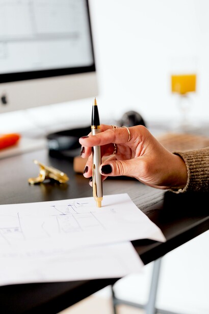 Mulher pensa enquanto escreve com caneta