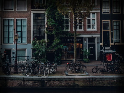 Amsterdam, Netherlands, a bicycling city, bikes are seen parked all along the river's edge